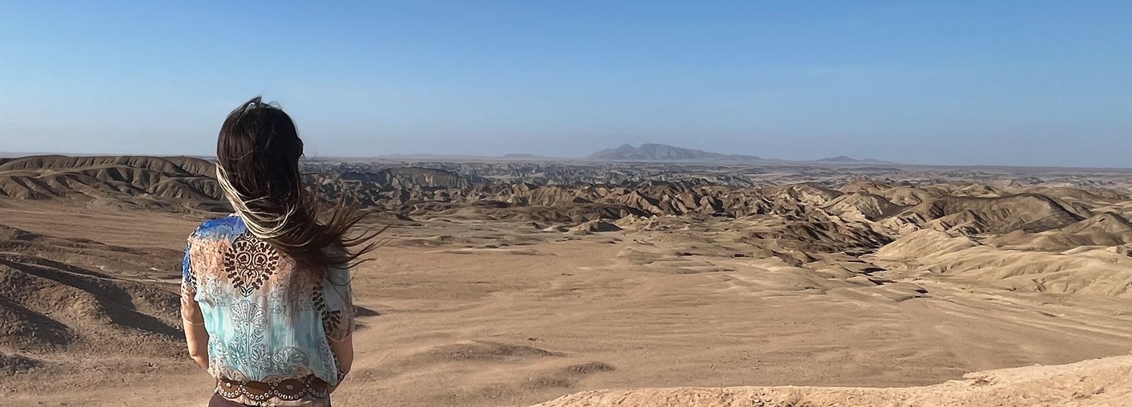 Kathleen Schütz blickt über eine weite Wüstenlandschaft in Namibia
