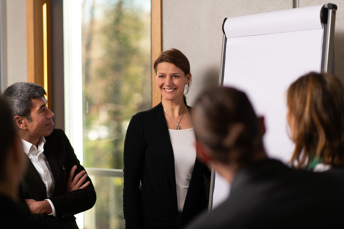 Kathleen Schütz im Gespräch mit zwei Führungskräften am Tisch
