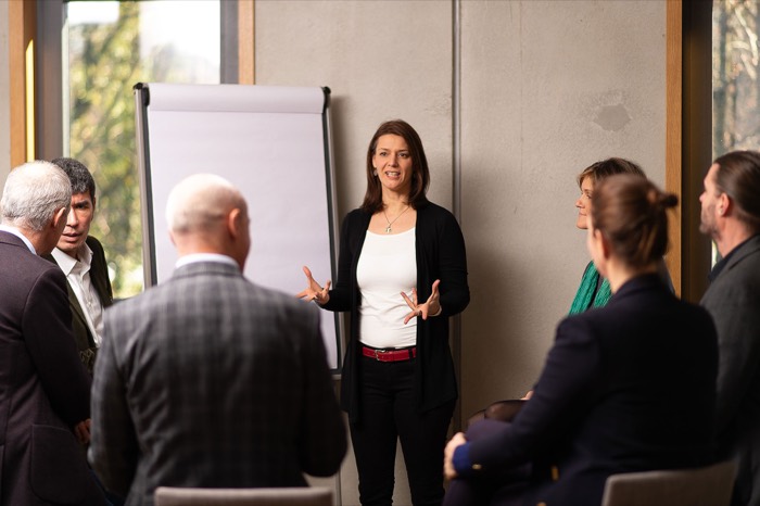 Kathleen Schütz moderiert einen Workshop mit Führungskräften am Flipchart